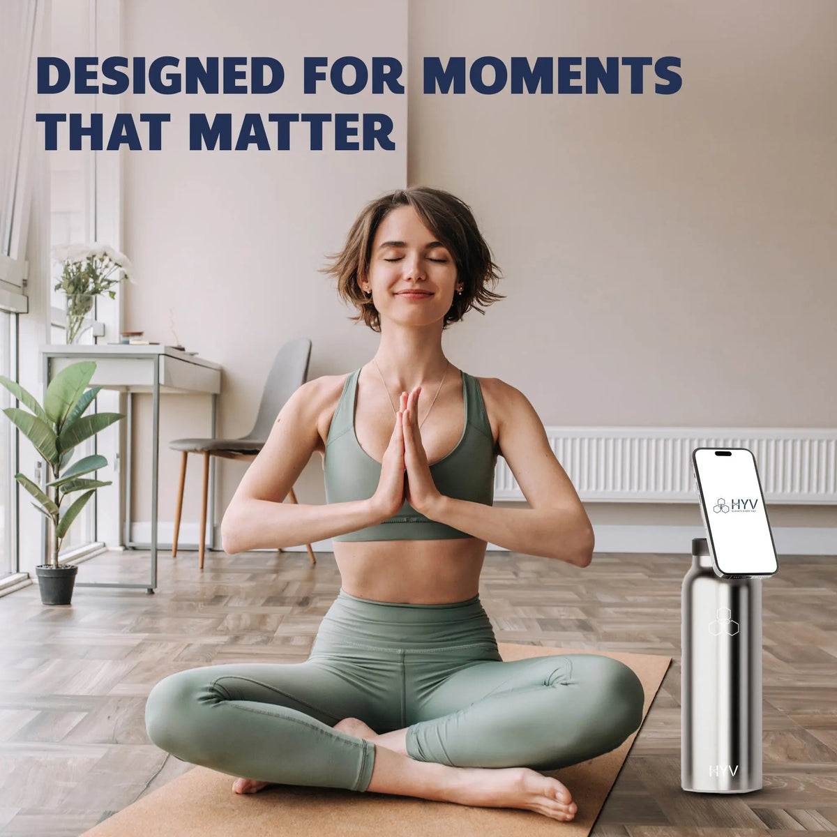Woman seated on a yoga mat with a HYV SnapSip bottle holding her phone upright beside her