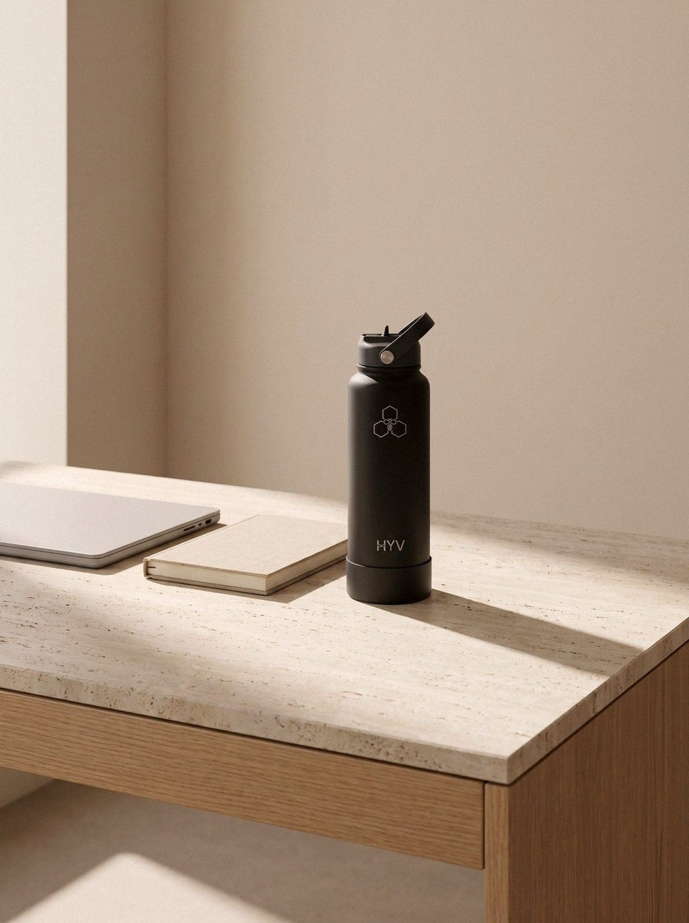 HYV LuxeSip in Midnight Black on a desk beside a laptop and notebook