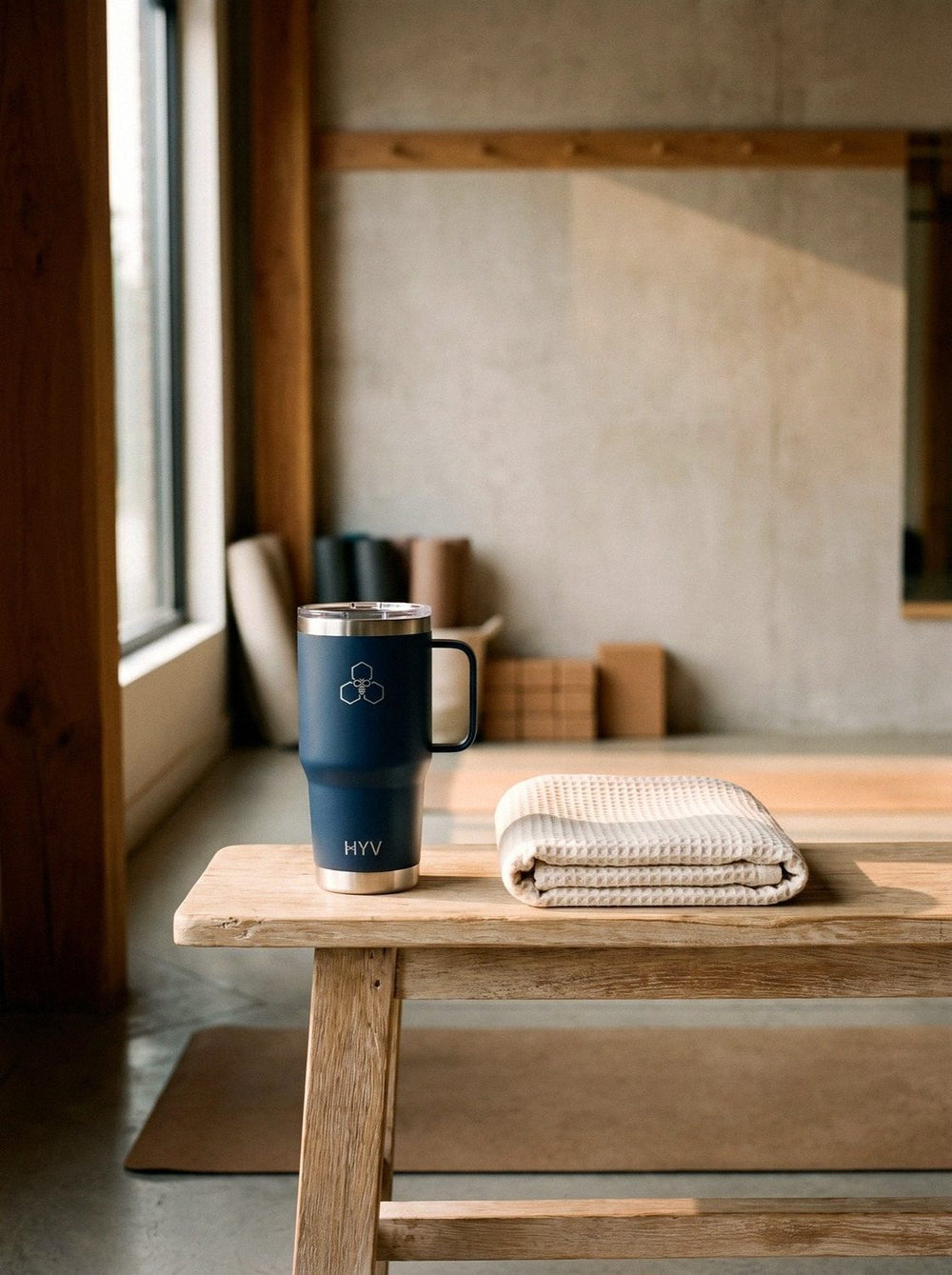 A HYV tumbler on a wooden bench in a wellness studio